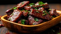 Glazed pork ribs with herbs served in wooden bowl on rustic table. Slow-cooked meat in sweet and savory Asian-style marinade garnished with fresh cilantro.