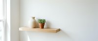 Wooden shelf with ceramic vase and potted succulent plant against white wall near window, minimalist home decor and interior design.