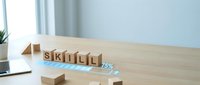 Wooden blocks spelling SKILL on a desk with a glowing digital progress bar at 75%, symbolizing professional growth and learning.