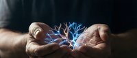 Hands holding glowing blue electric energy between palms against dark background, representing power, innovation, technology, and connection for business and science concepts.