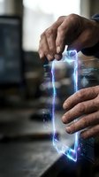 Male hands holding glowing digital holographic frame with blue neon light effects and data visualization, representing technology, innovation, and futuristic digital interface interaction.