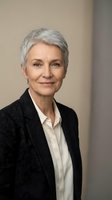 Senior woman with short gray hair, Caucasian ethnicity, wearing black blazer and white shirt. Professional business portrait for corporate, executive, and leadership applications.