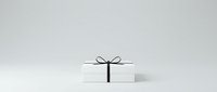 White gift box with black ribbon bow on neutral background, isolated and ready for holiday, celebration, and promotional design projects.