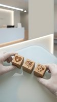 Medical professional hands in gloves holding wooden blocks with healthcare symbols in modern clinic environment for patient education and communication.