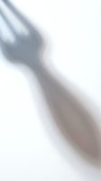 Blurred hand shadow silhouette on white wall creating soft artistic lighting effect for minimalist design projects and creative backgrounds.