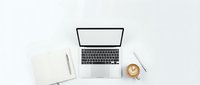 Modern workspace with open laptop, notebook and coffee cup on clean white desk for productivity and remote work concepts.