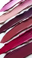 Diagonal smears of lipstick in various shades from light pink to deep burgundy on white background, showing texture and color gradients for cosmetic marketing.