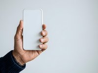 Person holding blank smartphone with empty screen for app mockup or mobile interface design.