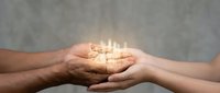 Diverse hands holding glowing light energy together, symbolizing unity, collaboration, teamwork, and shared vision for business success and growth.