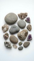 Collection of natural stones, crystals and smooth pebbles arranged on white background for geology, meditation and healing practices.