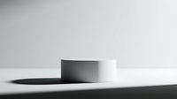 Minimalist white cylindrical podium on a clean surface with soft shadows, perfect for product display and presentation mockups.