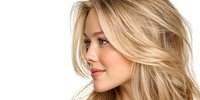 Young blonde woman with flowing hair in profile view isolated on white background for beauty and fashion design projects.