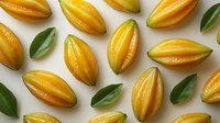 Fresh ripe starfruit slices arranged in pattern with green leaves on white background, tropical exotic carambola fruit composition for healthy food design.