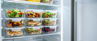 Variety of fresh meal prep containers with vegetables, proteins and grains organized in refrigerator for weekly healthy eating and nutrition planning.