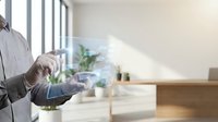 Professional businessman using digital tablet with holographic interface technology in modern office environment for business presentations and data analysis.