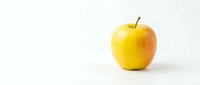Fresh yellow apple with red blush isolated on white background for healthy eating concepts and food photography projects.