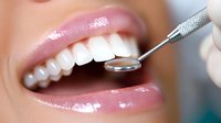 Close up of healthy white teeth during dental examination with mirror tool, showing professional oral care and dental hygiene procedure.