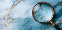 Vintage magnifying glass on luxury blue and gold marble texture background with copy space. Elegant detective or search concept layout.