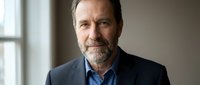 Middle-aged Caucasian male professional with beard wearing navy blazer and blue shirt, suitable for corporate, business, and executive portraits.