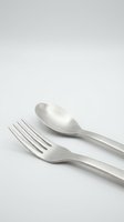 Elegant stainless steel fork and spoon cutlery set isolated on white background for kitchen dining restaurant culinary design projects.