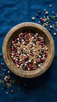 Mixed legumes and beans in rustic wooden bowl on blue linen background for healthy cooking and plant-based nutrition recipes.