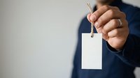 Professional holding blank white ID badge on lanyard for corporate identification, security access, or event credential display purposes.