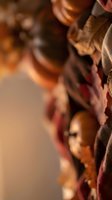 Close-up of rustic autumn harvest with walnuts, chestnuts and dried leaves in burlap sack creating warm seasonal atmosphere for fall decorating projects.