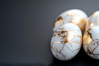 White marble eggs with gold crackle pattern on dark background, elegant decorative elements for luxury interior design and holiday decor.