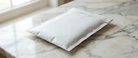 White pillow resting on marble surface near window with natural lighting for bedroom decor and home interior design concepts.
