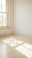 Empty room corner with natural sunlight streaming through window creating geometric shadows on wooden floor for interior design mockups.
