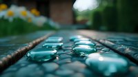 Water droplets on wooden surface with bokeh effect and daisies in background, macro photography showing nature's delicate details in turquoise and brown tones.