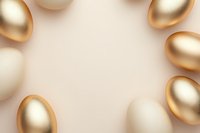 Golden and white eggs arranged in circular frame on beige background creating elegant Easter or prosperity concept composition with copy space in center.