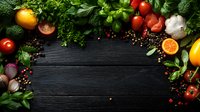 Fresh vegetables, fruits, herbs and spices creating frame border on dark wooden background. Raw organic produce arranged with copy space for menu design.