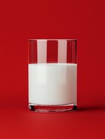 Fresh glass of milk on vibrant red background for healthy lifestyle and nutrition concepts.