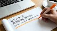 Build your personal brand business growth and reputation concept with hand writing on notebook at wooden desk workspace with laptop and coffee.