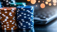 Stacked blue and orange poker chips on dark surface with blurred bokeh lights in background, creating atmospheric casino gaming ambiance.