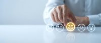 Business professional selecting positive feedback with glowing yellow smiley face icon among customer satisfaction rating symbols on modern interface.
