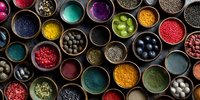 Colorful spices, seeds and powders in wooden bowls arranged in organized pattern. Natural ingredients for cooking, seasoning and food preparation.