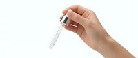 Hand holding silver metal key between fingers on white background isolated for real estate and security concepts.