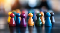 Colorful wooden game pieces arranged in row showing diversity and teamwork concept. Close-up view with selective focus and blurred background creates depth.