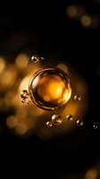 Golden oil bubbles floating in dark liquid with warm bokeh lights creating luxurious cosmetic or skincare product background for beauty industry marketing.
