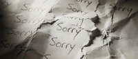 Crumpled paper with the word Sorry written repeatedly, conveying guilt, regret, and apology in a dramatic close-up monochrome composition.