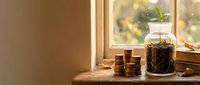 Cozy kitchen windowsill with glass jar of dried herbs, wooden spoons and warm natural lighting creating peaceful cooking atmosphere for home decor.