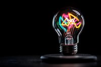 Glowing neon word IDEA inside light bulb on dark background, creative inspiration and innovation concept for business solutions and marketing.