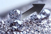 Upward arrow with sparkling diamonds on glittering silver surface represents growth, success and luxury in business and investment markets. Suitable for finance concepts.
