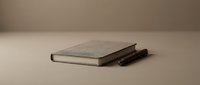 Closed notebook with pen on neutral surface for business, education, and creative projects.