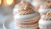 Elegant French macarons with cream filling and golden sprinkles on white surface. Luxury dessert photography for bakery menus and confectionery marketing.