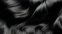 Luxurious black hair waves with smooth, glossy texture and natural shine. Close-up of flowing dark tresses showcasing healthy strands for beauty and haircare advertising.