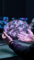 Hands holding glowing digital brain with neural network connections in purple light against blurred city background for AI technology concepts.