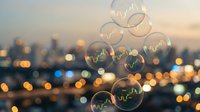 Soap bubbles floating against blurred city lights at sunset creating dreamy bokeh effect with warm golden hour atmosphere for creative projects.